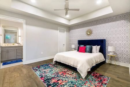 Serene queen bedroom w/ crisp white bedding & a pop of color from accent pillows.