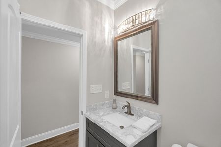 Newly constructed second bathroom w/ warm wood-framed mirror & modern fixtures.