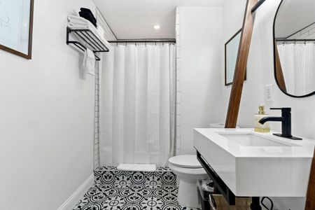 Clean, white bathroom w/ a tub & shower curtain — simple & fresh.