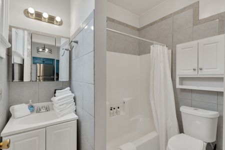 Spotless bathroom w/ fresh towels stacked & ready — clean & hotel-crisp.