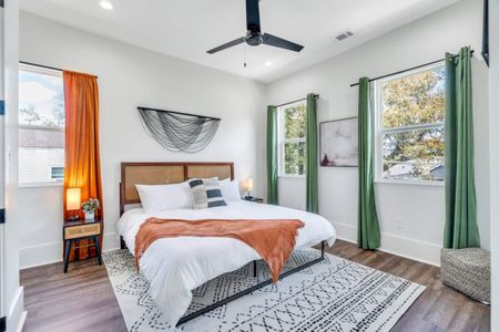 Upstairs king bedroom bathed in natural light w/ vibrant orange accent wall.