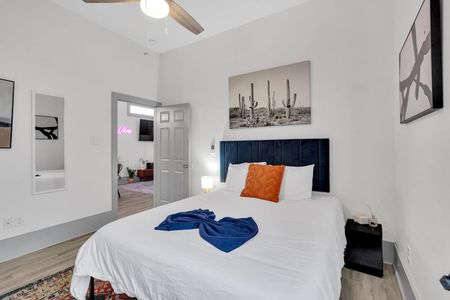 Cozy bedroom w/ plush bed, navy throw, & warm earthy tones for a restful retreat.