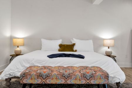Clean lines, soft linens, and a touch of color give this bedroom a fresh, welcoming feel—ideal for couples or solo travelers.