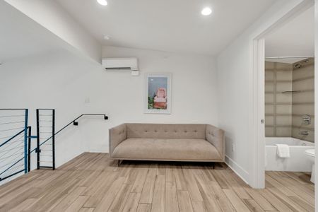 A quiet landing space with a comfy sofa and direct access to a full bathroom—perfect for reading or a private moment.