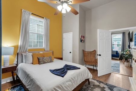 Sun-filled bedroom w/ yellow accents & a seating area to unwind.