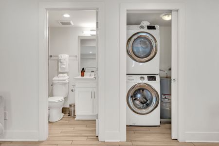 Stay fresh with the convenience of a washer and dryer right next to a bright, modern bathroom stocked with essentials.