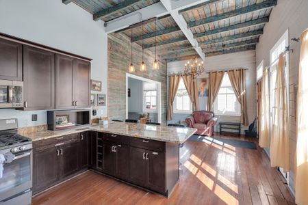 Rustic-chic kitchen w/ industrial pendants & rich wood tones.