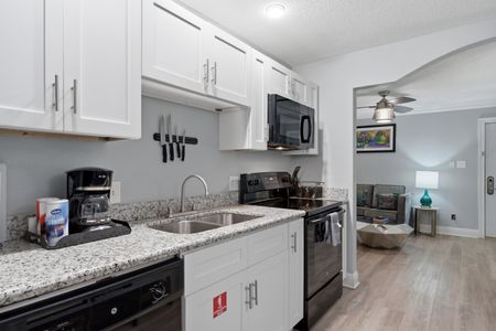 Sleek kitchen w/ granite counters, sink & full appliances.