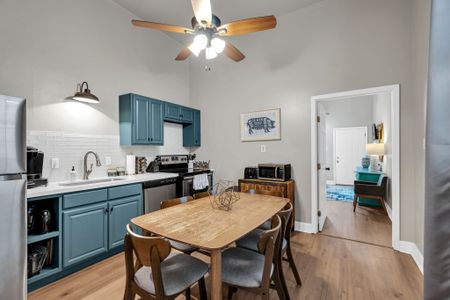Fully equipped kitchen w/ teal cabinets & a wooden dining table for shared meals.