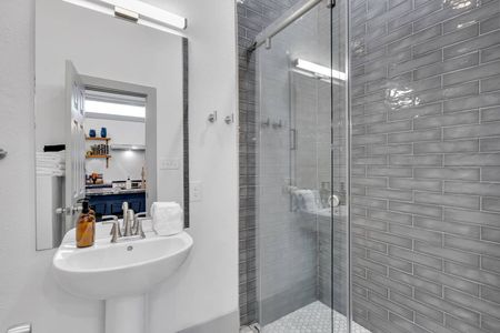 Sleek bathroom w/ gray subway tiles, tub & shower combo, & clean modern finishes.