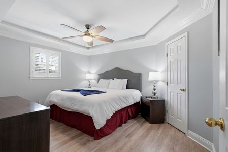 Bright bedroom w/ ceiling fan & soft linens for a peaceful night's sleep.