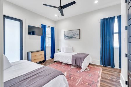 Upstairs bedroom w/ two twin beds, bold blue curtains & its own en-suite bath.