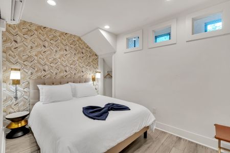 Serene bedroom w/ bold accent wall & soft lighting for a peaceful night's rest.
