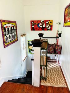 Vibrant wall art & a bold yellow door adding personality to the space.