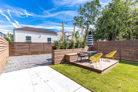 Backyard w/ parking, lounge seating & lush green space to relax & play.