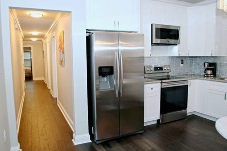 Stainless steel fridge & fully equipped kitchen ready for home-cooked meals.