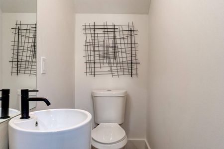 Chic half bath w/ modern fixtures & a sleek, stylish finish.