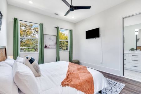 Upstairs king bedroom w/ green curtains, bright light & a relaxed, airy vibe.