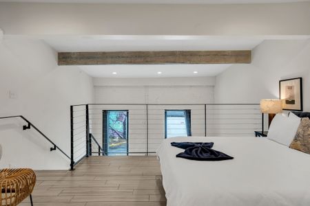 Sunlit bedroom w/ exposed beam & relaxed, airy vibe.