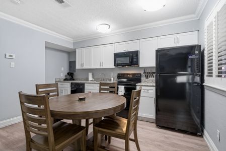 Modern kitchen w/ warm wood tones & full appliances.