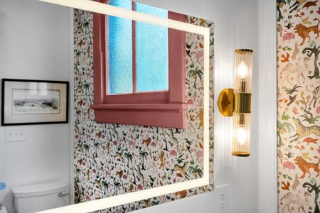 Playful bedroom w/ floral wallpaper & warm gold lighting for a boutique-hotel feel.
