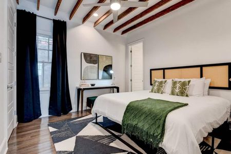 Serene master bedroom w/ a lush green bed & ensuite bath — your private retreat.