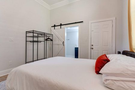 Serene master bedroom w/ a barn door leading to the en suite — a peaceful retreat to come home to.