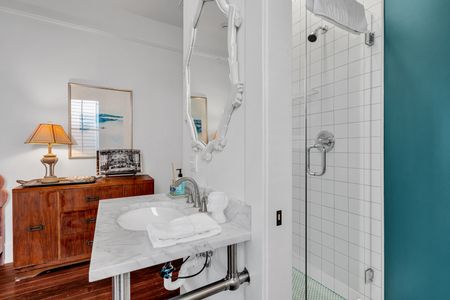 Bright, clean bathroom w/ a glass-enclosed shower.