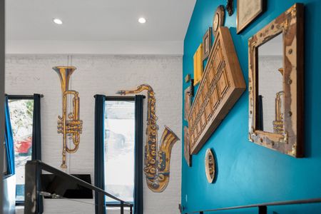 Trumpet & ornate framed art on a teal wall celebrate the city's rich musical heritage.