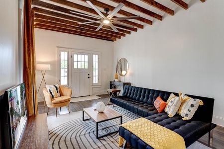Bright living room w/ exposed brick, bold blue sofa & warm wood accents — made for gathering.