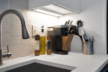 Compact kitchen w/ everything you need, tucked behind an exposed brick wall.