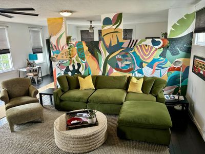 Sink into the plush green sofa & let the colorful mural set the mood for your stay.