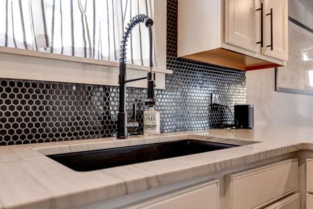 Bold mosaic backsplash adds a stylish touch to the kitchen.