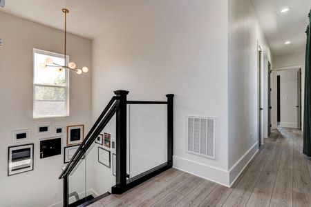 Elegant staircase w/ dark wood railings & open, airy feel.