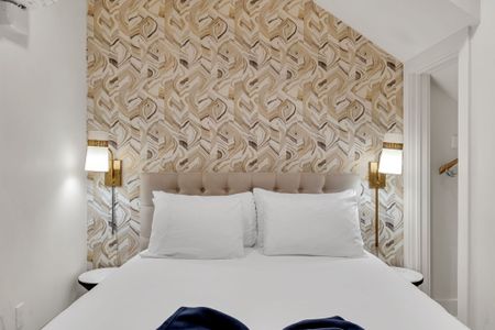 Dreamy sleeping space w/ a bold feature wall & soft ambient lighting.