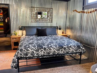 Plush king bed w/ bold patterned linens — rest well before your next adventure.