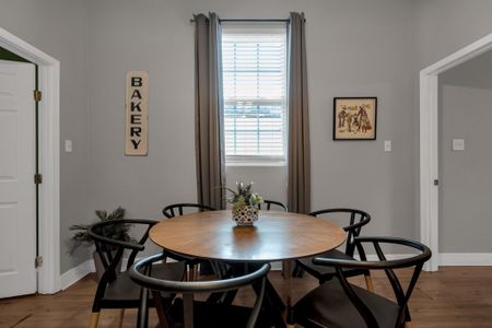 Round dining table w/ bistro chairs under warm light — a great spot for shared meals.