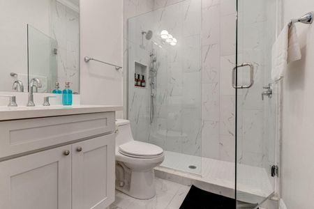Ensuite master bath w/ a sleek tiled shower & modern finishes.