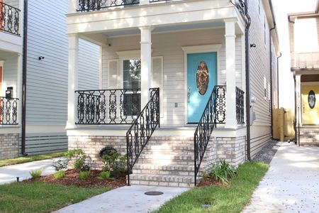 Charming front entrance w/ classic ironwork balcony & a welcoming teal door.