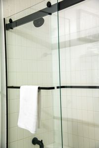 Step into a clean, glass-enclosed shower designed for a refreshing start to the day.