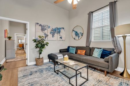 Bright living room w/ a cozy sofa, world map wall art & plenty of natural light.