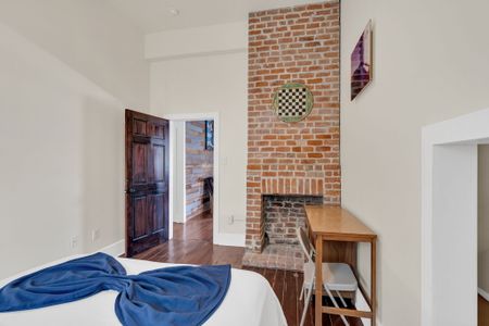 Original exposed brick fireplace bringing warmth & historic NOLA soul.