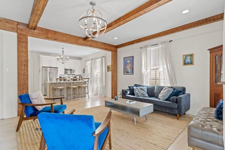 Sun-filled living room w/ blue accents & tasteful New Orleans-style decor.