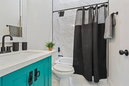 Teal-accented bathroom w/ a sink & bright, clean finishes.