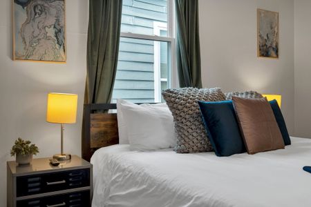Soft, pillow-lined bed w/ warm lamplight — wake up slowly & settle in.