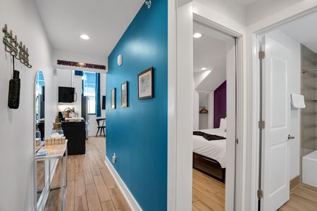 Teal hallway w/ vibrant accents connects rooms w/ bold, flowing energy.