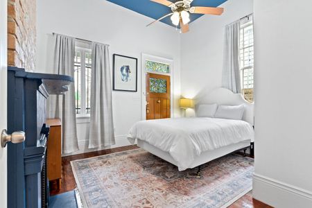 Sun-lit bedroom w/ a queen bed & warm wood tones for a restful night's sleep.