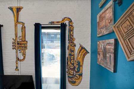 Gold saxophone wall art paired w/ expressive brushstrokes — pure New Orleans soul.