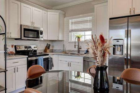 Modern kitchen w/ stainless steel appliances & generous counter space.