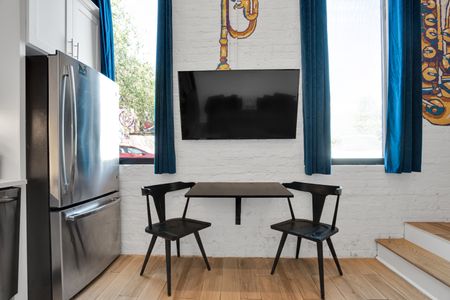 Dining area w/ a sleek table & wall-mounted TV — great for meals or movie nights.